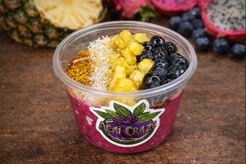 Tropical Bliss Bowl: pink pitaya base topped with pineapple, blueberries, coconut and bee pollen
